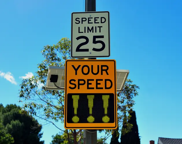 Speed limit sign indicating 25 mph with a digital speed display showing current speed, promoting safe driving in residential areas.